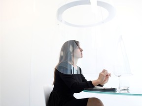 A woman poses under a Plex'Eat prototype plexiglas bubble by designer Christophe Gernigon which surrounds diners to protect them from the novel coronavirus during a presentation in Cormeilles-en-Parisis, near Paris, as restaurants in France prepare to re-open post-lockdown, May 20, 2020.