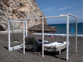 A plexiglas construction is set around an umbrella and sunbeds as a precaution against the coronavirus disease (COVID-19), on the beach of Perissa on the island of Santorini, Greece, May 7, 2020.