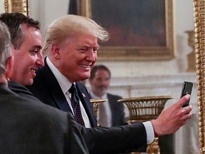 U.S. President Donald Trump poses for a selfie with Will Guidara of the Independent Restaurant Coalition at the conclusion of a coronavirus disease (COVID-19) pandemic meeting with restaurant executives and industry leaders in the State Dining Room at the White House in Washington, U.S., May 18, 2020.