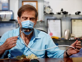 Meir Gitelis, co-developer of an Israeli company, eats while wearing a mask fitted with a mechanical mouth that opens to enable diners to eat without taking it off.