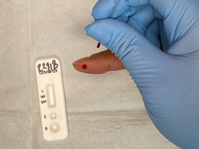 A medical practitioner takes a blood sample for the COVID 19 IgG and IgM Rapid Test, designed to detect the coronavirus antibodies.