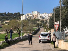 Daniele Perrini's family members stand outside their homes in the small southern historical town of Cisternino, Italy, March 29, 2020. Picture taken March 29, 2020.