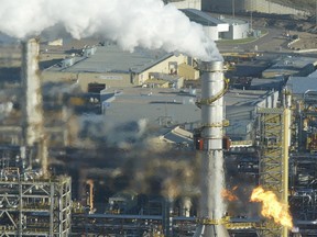 A stack belches smoke and a flare burns off gas at the Syncrude upgrader plant near Fort McMurray, Alta., in 2006.