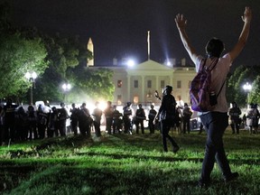 A protester holds his hands up as police officers enter Lafayette Park during a demonstration against the death in Minneapolis police custody of African-American man George Floyd, as the officers keep demonstrators away from the White House during a protest in Washington, U.S. May 30, 2020.