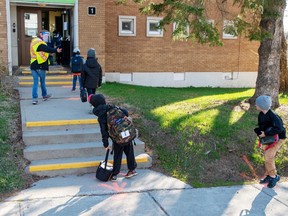 Students maintain social distancing at Ecole Marie Rose as elementary schools outside the greater Montreal area reopen Monday May 11, 2020 in Saint Sauveur, Que.. Schools and daycare centers have been closed due to the COVID-19 pandemic.
