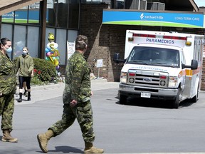 Members of the Canadian Armed Forces walk in front of Pickering's Orchard Villa long-term care home on Wednesday, May 6, 2020.