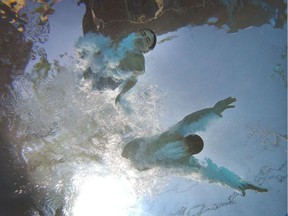 Brothers Alex and Carter Dalipaj cool off swimming in their pool during a heat wave in Ottawa Wednesday.