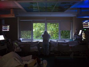 A doctor at Moscow City Clinical Hospital 52 wears personal protective equipment and looks out the window as night falls in the intensive care unit in Moscow, Russia, on May 13, 2020. Russia has the world’s second-highest number of coronavirus infections with more than 300,000 cases so far.