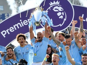 In this file photo from May 12, 2019, Manchester City skipper Vincent Kompany lifts the trophy as the team celebrates the Premier League title.