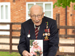 Former British Army Officer Captain Tom Moore poses for a picture with a card he received from Britain's Queen Elizabeth for his 100th birthday, Bedfordshire, England, April 30, 2020.