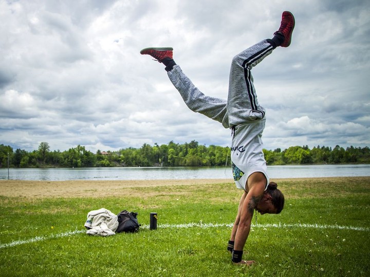  OTTAWA — May 30, 2020 — Nick Shea works on his handstands inside a circle painted on the grass at Mooney’s Bay Saturday, May 30, 2020.
