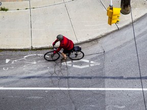A cyclist rides along Bay St.