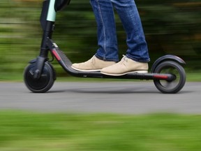 A man rides an E-Scooter.