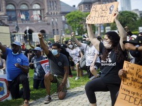 People take a knee on the lawn of Queen's Park recently during an anti-racism march in Toronto. The death of George Floyd has led to soul-searching and more open dialogue around questions of race.