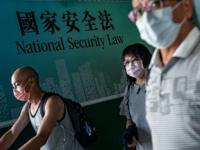 Pedestrians walk past a government-sponsored advertisement promoting a new national security law on June 30, 2020 in Hong Kong.