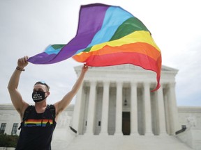 Joseph Fons holding a Pride Flag, stands in front of the U.S. Supreme Court building on June 15 after the court ruled that LGBTQ people can not be disciplined or fired based on their sexual orientation.