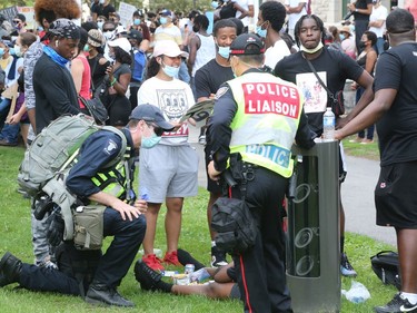Police and paramedics helps someone who wasn't feeling well while thousands gathered on Elgin Streets at the Human Rights Monument to protest/march for George Floyd, June 05, 2020.