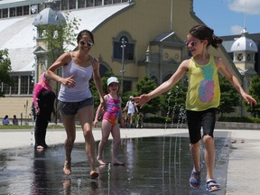 OTTAWA- June 19, 2020 --Nancy Petrie (L) and her daughter Naomi, 10 yrs old,  play in the water features at TD Place in Ottawa, June 19, 2020.