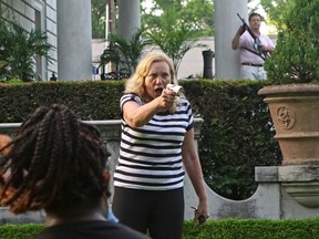 A man and woman draw their firearms on protestors as they enter their neighbourhood during a protest against St. Louis Mayor Lyda Krewson, in St. Louis, Missouri, U.S. June 28, 2020.