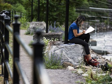 Diana Jung sits along the Ottawa River at the Pumphouse whitewater course on Saturday afternoon.