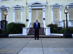US President Donald Trump holds a bible in front of boarded up St John's Episcopal church after walking across Lafayette Park from the White House in Washington, DC on June 1, 2020. - US President Donald Trump was due to make a televised address to the nation on Monday after days of anti-racism protests against police brutality that have erupted into violence. The White House announced that the president would make remarks imminently after he has been criticized for not publicly addressing in the crisis in recent days.