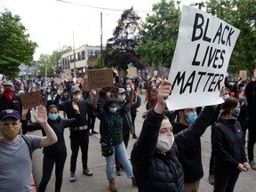 People hold up placards to protest the death of George Floyd, an unarmed African-American man who died in police custody in Minneapolis on May 25.