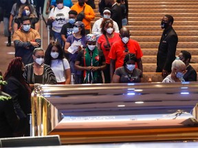 Mourners wait in line to pass by the casket of George Floyd during a public viewing at the Fountain of Praise church Monday, June 8, 2020, in Houston.