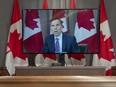 Remote figure? Minister of Finance Bill Morneau is displayed on a television screen as he participates in a daily COVID-19 briefing by video conference in Ottawa.