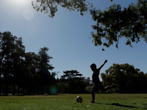 FILE: A child plays with a soccer ball in a park.