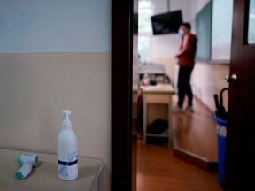 FILE PHOTO: A thermometer and a sanitising gel are seen outside a classroom during a government-organised media tour at a high school as more students returned to campus following the coronavirus disease (COVID-19) outbreak, in Shanghai, China May 7, 2020.
