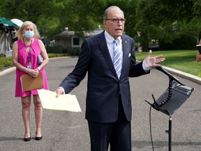 Files: Aides wearing masks stand behind White House economic adviser Larry Kudlow at the White House in Washington on May 15.