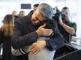 Ryan Pourjam, 13, son of Mansour Pourjam, is embraced by family friend Mahmoud Rastgou, after a ceremony at Carleton University to honour Pourjam, a biology alumnus on Jan. 15, 2020.