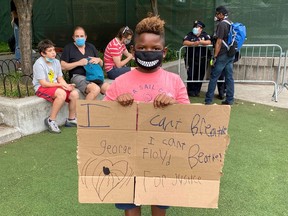 Corte Ellis, 10, holds a sign he made as he attends a memorial in Brooklyn's Cadman Plaza Park for George Floyd, who died in Minneapolis police custody, in New York, U.S. June 4, 2020.