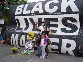 A family poses for a photo in front of a Black Lives Matter banner near the White House in Washington, June 10.