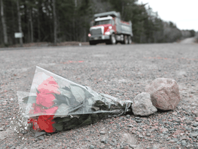 Flowers lay at the side of a road in Debert, Nova Scotia, where two of the 22 victims of a mass shooting were killed.