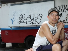Jack Nguyen sits beside his Rideau Street chip truck, which was recently spray-painted with hate graffiti.