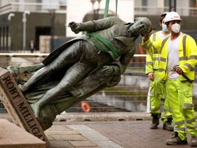 A statue of Robert Milligan is pictured being removed by workers outside the Museum of London Docklands near Canary Wharf, following the death of George Floyd who died in police custody in Minneapolis, London, Britain, June 9, 2020.