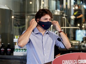 Canada's Prime Minister Justin Trudeau removes his face mask as he visits the Big Rig Brewery, which utilizes the Canada Emergency Wage Subsidy given to businesses affected by the coronavirus disease (COVID-19) outbreak, in Kanata, Ontario, Canada June 26, 2020.