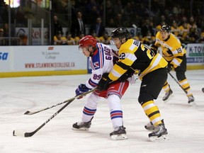 Kitchener's Eric Guest tries to protect the puck against Kingston's Jakob Brahaney during an Ontario Hockey League game in Kingston in February 2018.