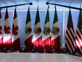 File photo/ National flags representing Canada, Mexico, and the U.S. are lit by stage lights at the North American Free Trade Agreement, NAFTA, renegotiations, in Mexico City.