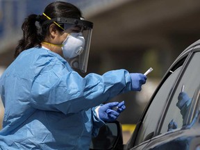 A San Diego County health nurse collects a sample from a patient at a drive-in COVID-19 testing site during the global outbreak of the coronavirus disease (COVID-19) in San Diego, California.