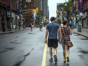 A couple strolls down Bank Street, closed to traffic during the pandemic. Everyone fears COVID-19, but some people have less to fear than others.