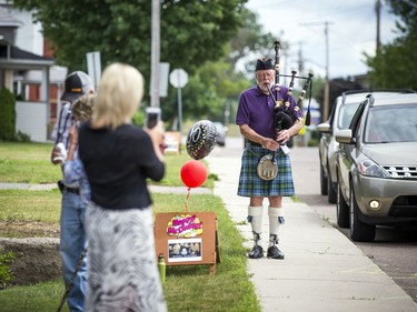 Piper Clark Smith of the Renfrew Highland Pipes and Drums kept the tunes playing as the drive by party took place.