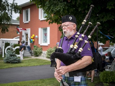 Piper Clark Smith of the Renfrew Highland Pipes and Drums kept the tunes playing as the drive by party took place.