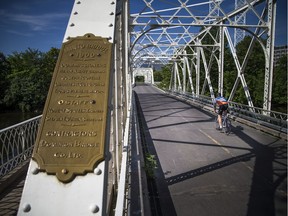 Ottawa -- July 26, 2020 -- It was a beautiful morning for people to beat the heat on Sunday July 26, 2020. A cyclist crosses over the Minto Bridge, spanning the Rideau River in New Edinburgh.