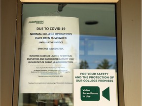 A sign about physical distancing is affixed to the entrance of an Algonquin College building on Tuesday.