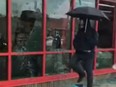 The mysterious 'Umbrella Man' is seen smashing windows.