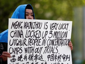 A woman holds a sign protesting China's treatment of Uighur people in the Xinjiang region during a court appearance by Huawei's Financial Chief Meng Wanzhou in Vancouver last year.