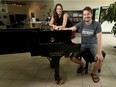 Jennifer Messer, manager of the Steinway Piano Gallery, and pianist Carson Becke pose with the nine-foot Steinway grand piano on Thursday. The store is starting outdoor "drive-in" concerts with it, and Becke will be performing outside the store twice on Monday morning, weather permitting.