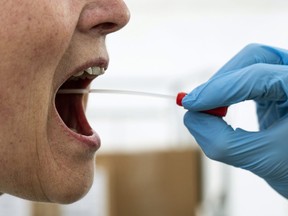 A medical worker performs a mouth swab on a patient to test for Covid-19 coronavirus on Thursday, April 2, 2020.